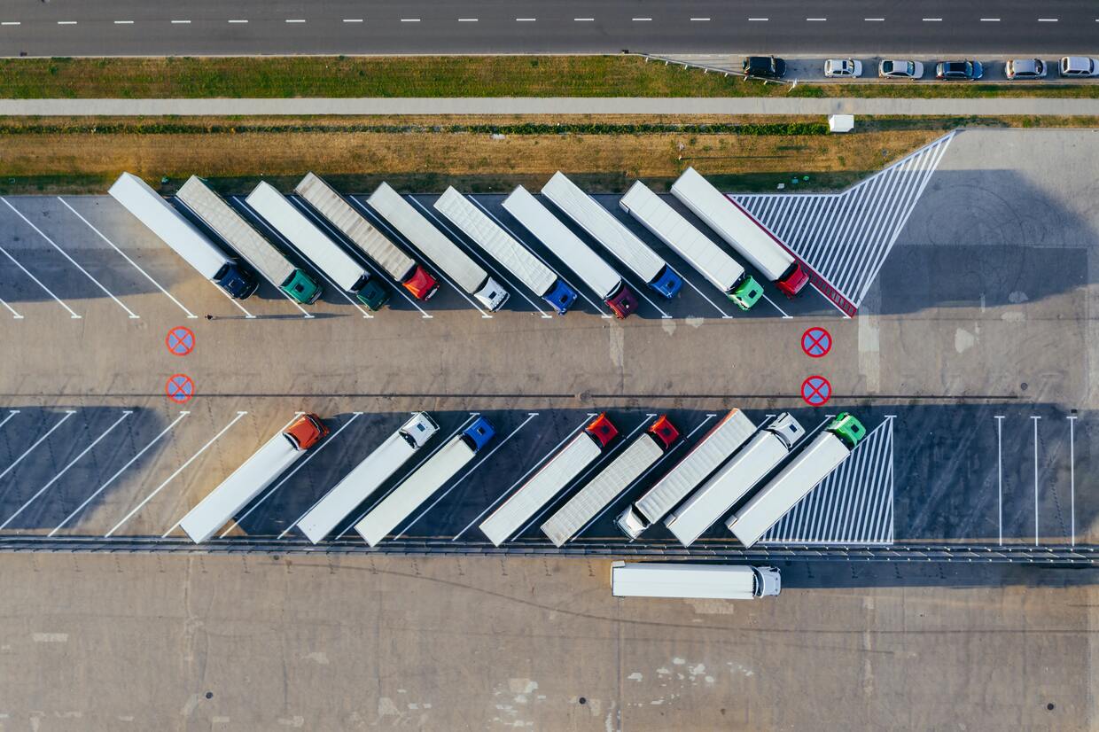 Camiones con contenedores desde una vista aéra aparcados en diagonal